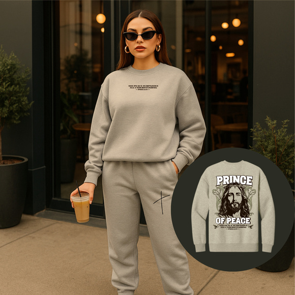 Woman wearing a gray sweatshirt with text, holding a drink, with an inset of a 'Prince of Peace' graphic on a gray sweatshirt.