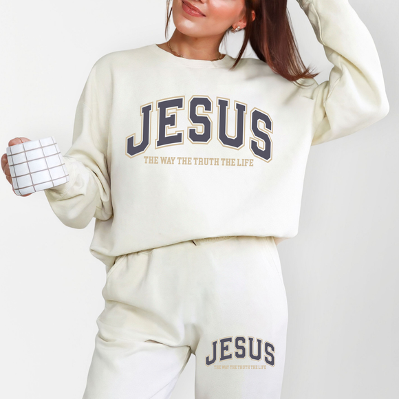 Person wearing a 'Jesus' sweatshirt and pants holding a mug with a white background