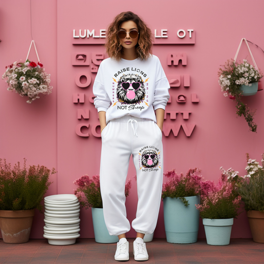 Person wearing a white sweatshirt and pants with a graphic design in front of a pink wall with decorative letters and plants.