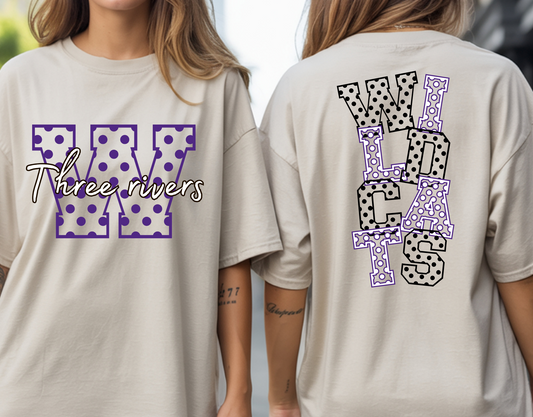 A woman modeling a beige oversized T-shirt shown from both front and back. The front has a large purple polka-dot 'W' with 'Three rivers' script across it.