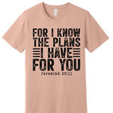 A 3x3 grid showing nine light peach-beige short-sleeve T-shirts, each with a different inspirational Bible verse or quote printed on the front in various colors and styles.
