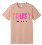 A 3x3 grid showing nine light peach-beige short-sleeve T-shirts, each with a different inspirational Bible verse or quote printed on the front in various colors and styles.