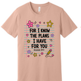 A 3x3 grid showing nine light peach-beige short-sleeve T-shirts, each with a different inspirational Bible verse or quote printed on the front in various colors and styles.