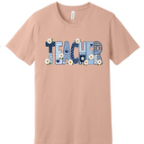 A 3x3 grid showing nine peach-colored short-sleeve t-shirts, each with a different colorful teacher-themed graphic design such as an apple, lightning bolt, and text slogans.