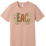 A 3x3 grid showing nine peach-colored short-sleeve t-shirts, each with a different colorful teacher-themed graphic design such as an apple, lightning bolt, and text slogans. 