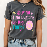 A 3x3 grid showing nine different dark gray graphic t-shirts modeled on a person. The shirts feature various colorful and white inspirational Christian-themed designs including 'HAPPY TO SEE YOUR FACE', 'TEACHER YOU ARE', 'AMEN TEACHERS', and 'JESUS'.