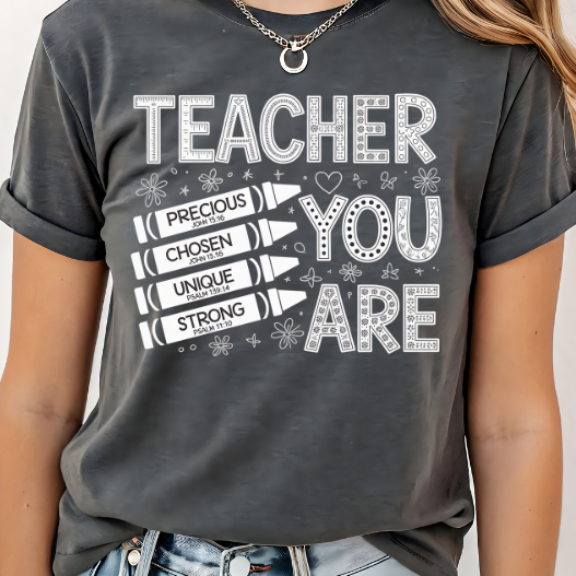 A 3x3 grid showing nine different dark gray graphic t-shirts modeled on a person. The shirts feature various colorful and white inspirational Christian-themed designs including 'HAPPY TO SEE YOUR FACE', 'TEACHER YOU ARE', 'AMEN TEACHERS', and 'JESUS'.