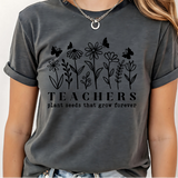 A 3x3 grid showing nine different dark gray graphic t-shirts modeled on a person. The shirts feature various colorful and white inspirational Christian-themed designs including 'HAPPY TO SEE YOUR FACE', 'TEACHER YOU ARE', 'AMEN TEACHERS', and 'JESUS'.