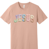 A 3x3 grid showing nine short-sleeve crew-neck T-shirts in a light peach-beige color, each with a different teacher-themed graphic print on the front, displayed against a plain white background.