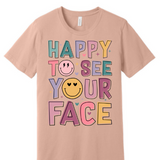 A 3x3 grid showing nine short-sleeve crew-neck T-shirts in a light peach-beige color, each with a different teacher-themed graphic print on the front, displayed against a plain white background.