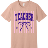 A 3x3 grid showing nine short-sleeve crew-neck T-shirts in a light peach-beige color, each with a different teacher-themed graphic print on the front, displayed against a plain white background.